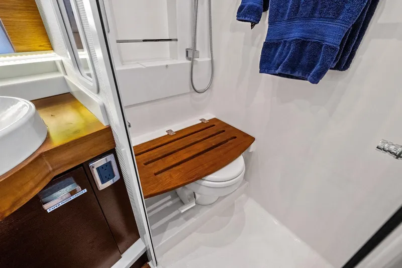 Slide: The Image of 2018 Tiara Yachts C44 Coupe bathroom with wooden seat and blue towel. - 67