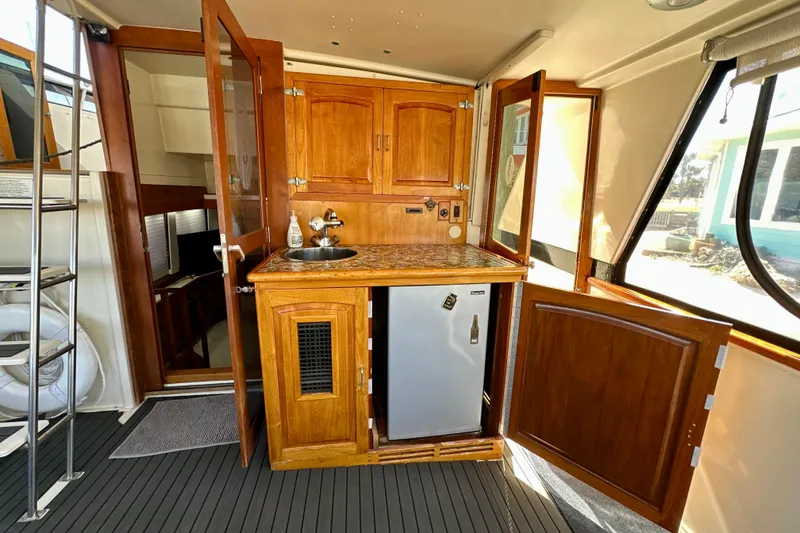 Slide: The Image of 1988 Californian 45 Motor Yacht interior with wooden cabinetry and compact kitchenette. - 11