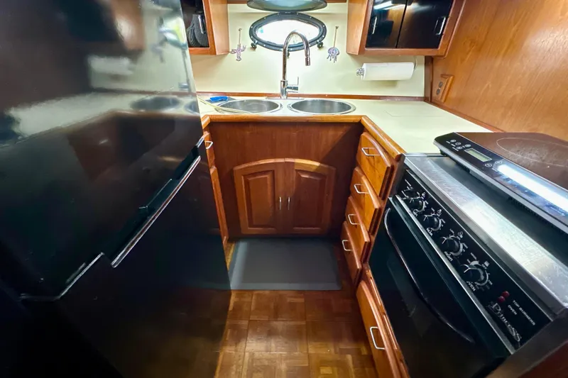 Slide: The Image of 1988 Californian 45 Motor Yacht kitchen with stove, sink, and wooden cabinetry. - 16