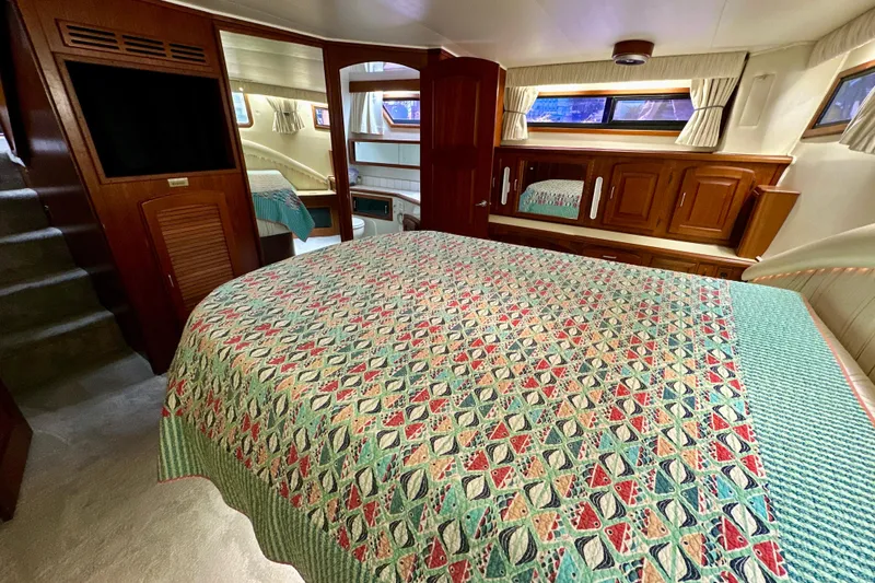 Slide: The Image of 1988 Californian 45 Motor Yacht interior with patterned bedspread and wooden cabinetry. - 24