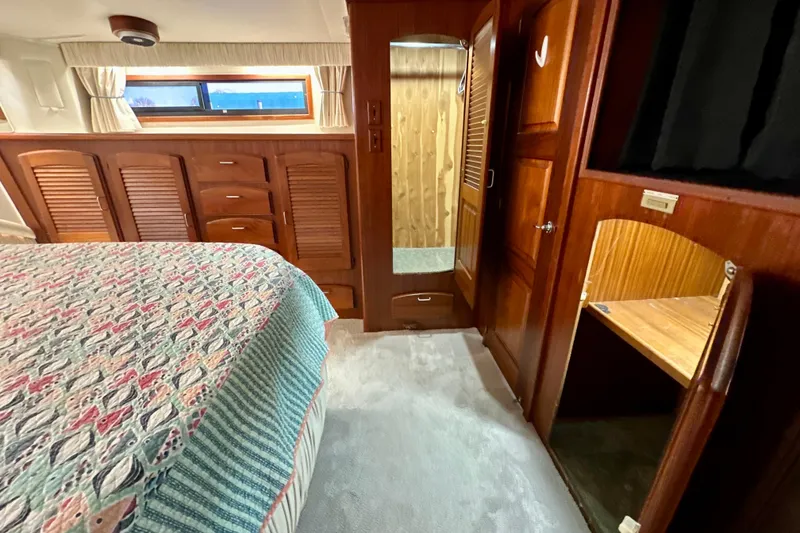 Slide: The Image of Interior of 1988 Californian 45 Motor Yacht with wood cabinetry and patterned bedding. - 25
