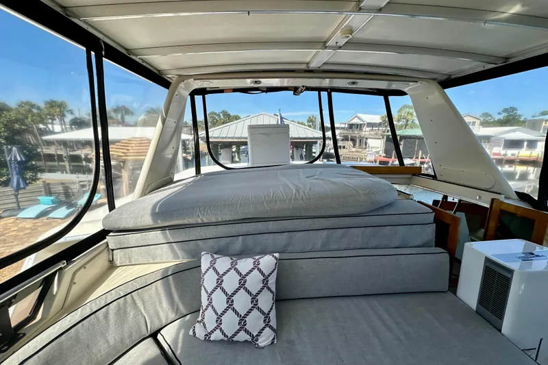Slide: The Image of Interior of 1988 Californian 45 Motor Yacht with cushioned seating and scenic marina view. - 29