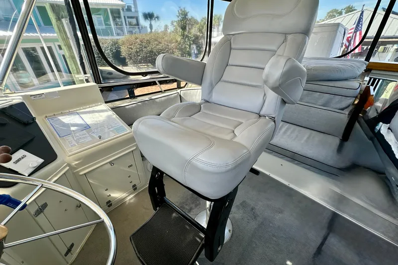 Slide: The Image of Captain's chair in 1988 Californian 45 Motor Yacht cockpit, featuring navigation controls and panoramic windows. - 32