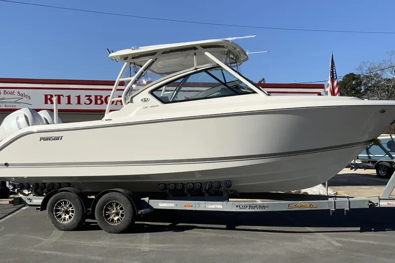 The Image of 2026 Pursuit DC 266 Dual Console boat on trailer at dealership. - 1