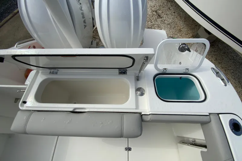 Slide: The Image of 2026 Pursuit DC 266 Dual Console boat with open storage compartments and seating. - 18