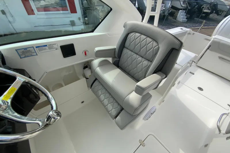 Slide: The Image of 2026 Pursuit DC 266 Dual Console boat interior with luxurious seating and steering wheel. - 19