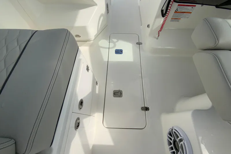 Slide: The Image of Interior of 2026 Pursuit DC 266 Dual Console boat, featuring seating and storage compartments. - 23