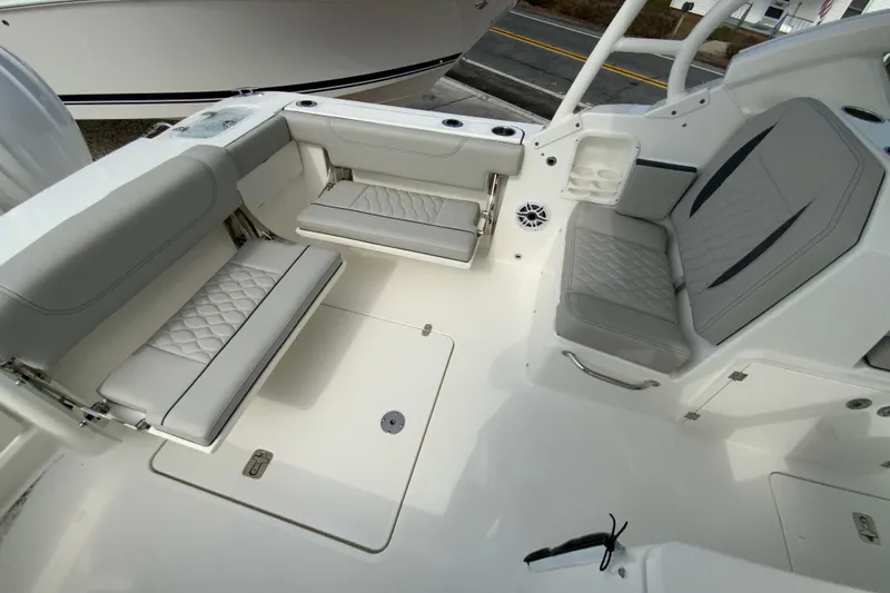 Slide: The Image of 2026 Pursuit DC 266 Dual Console boat interior with gray seating and storage compartments. - 7