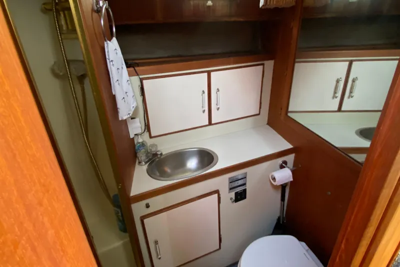Slide: The Image of 1986 Tollycraft Flybridge Convertible bathroom with sink, cabinets, and toilet. - 12