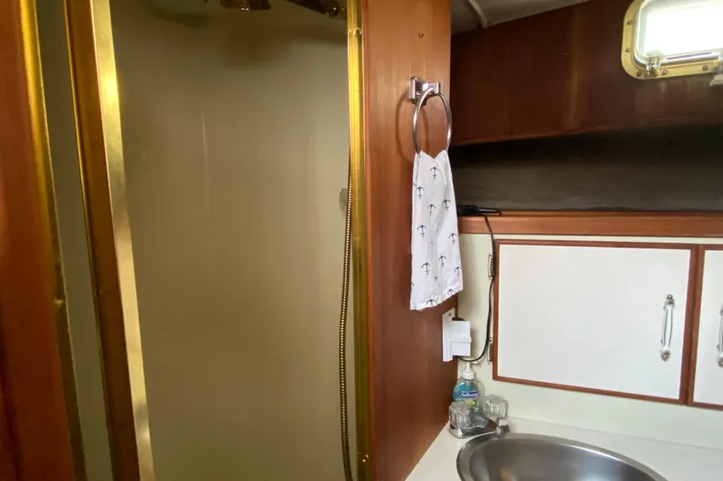 Slide: The Image of 1986 Tollycraft Flybridge Convertible bathroom with shower, sink, and towel rack. - 13