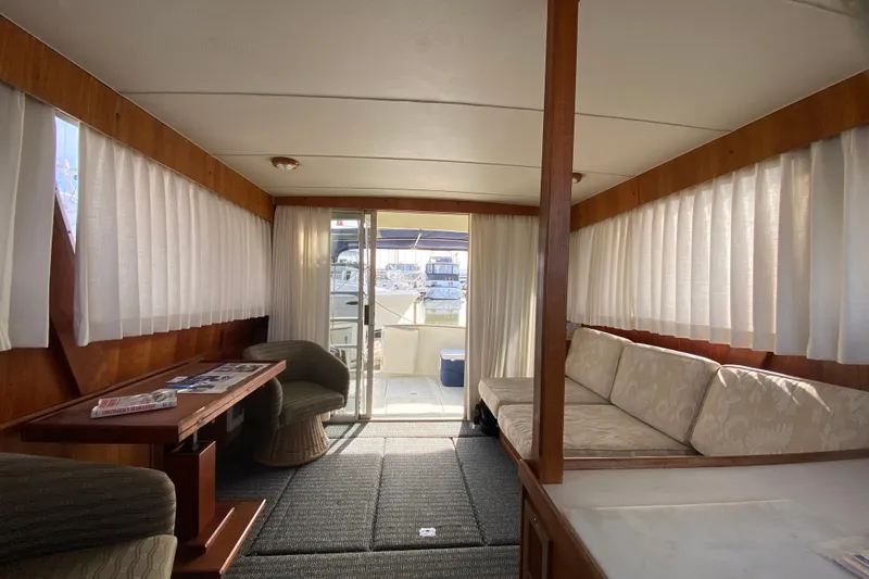 Slide: The Image of 1986 Tollycraft Flybridge Convertible interior with seating, table, and curtains. - 14