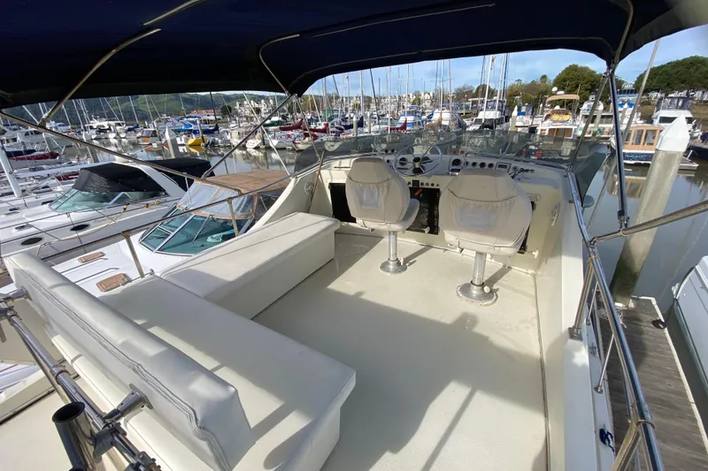 Slide: The Image of 1986 Tollycraft Flybridge Convertible yacht interior with helm, seating, and marina view. - 18