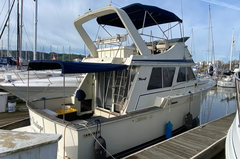 Slide: The Image of 1986 Tollycraft Flybridge Convertible yacht docked at marina, featuring classic design and spacious deck. - 3