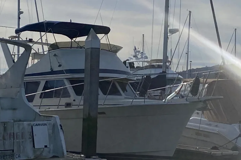 Slide: The Image of 1986 Tollycraft Flybridge Convertible yacht docked at marina, with blue canopy and sleek design. - 4