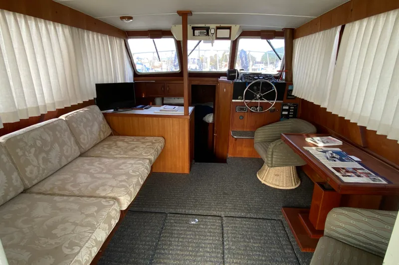 Slide: The Image of 1986 Tollycraft Flybridge Convertible interior with seating, helm, and table. - 5