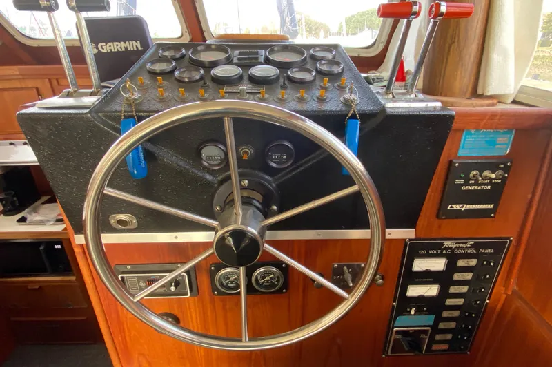 Slide: The Image of 1986 Tollycraft Flybridge Convertible helm with steering wheel and control panel. - 8