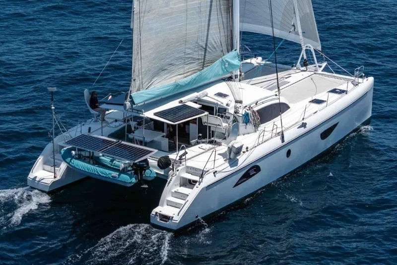 Slide: The Image of 2012 Outremer 49 catamaran sailing on open sea with solar panels and dinghy. - 1