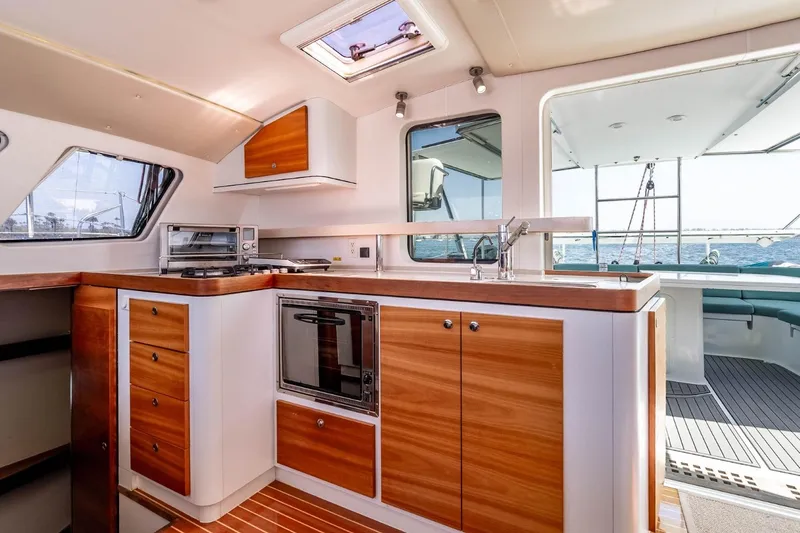 Slide: The Image of Interior of 2012 Outremer 49 yacht kitchen with wood cabinetry and ocean view. - 15