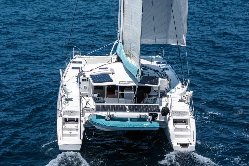 Slide: The Image of 2012 Outremer 49 catamaran sailing on open sea, featuring solar panels and white sails. - 3