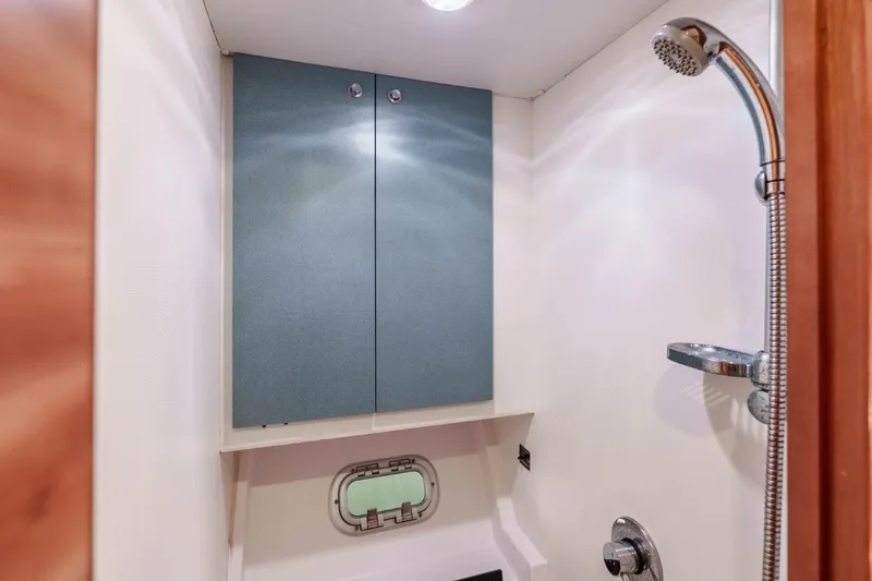 Slide: The Image of Compact bathroom with shower in 2012 Outremer 49 yacht, featuring storage cabinet and porthole. - 33