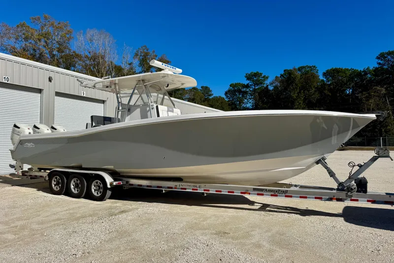 The Image of 2014 Invincible 36 Open Fisherman boat on trailer, parked near storage units. - 1
