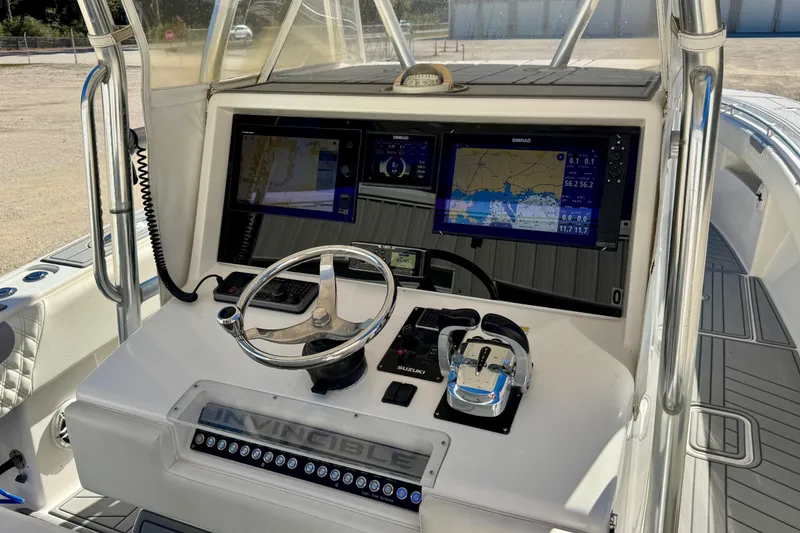 Slide: The Image of Control panel of 2014 Invincible 36 Open Fisherman with navigation screens and steering wheel. - 11