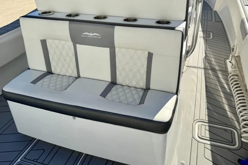 Slide: The Image of 2014 Invincible 36 Open Fisherman boat seating with cup holders and diamond-pattern upholstery. - 8