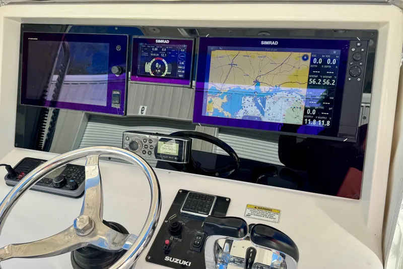 Slide: The Image of Control panel of 2014 Invincible 36 Open Fisherman with navigation screens and steering wheel. - 9