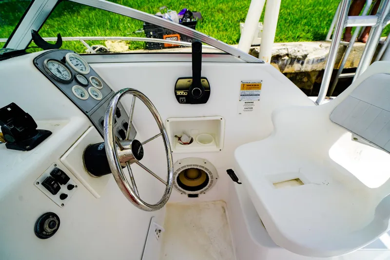 Slide: The Image of 1999 Pro-Line 201 Walkaround boat cockpit with steering wheel and control panel. - 12