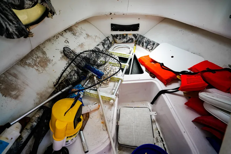 Slide: The Image of Interior of a 1999 Pro-Line 201 Walkaround boat with fishing gear and life jackets. - 18