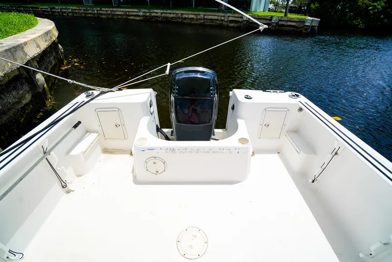 Slide: The Image of 1999 Pro-Line 201 Walkaround boat deck with motor, docked by a canal. - 6
