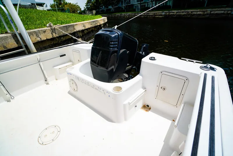 Slide: The Image of 1999 Pro-Line 201 Walkaround boat with outboard motor, docked by a canal. - 7
