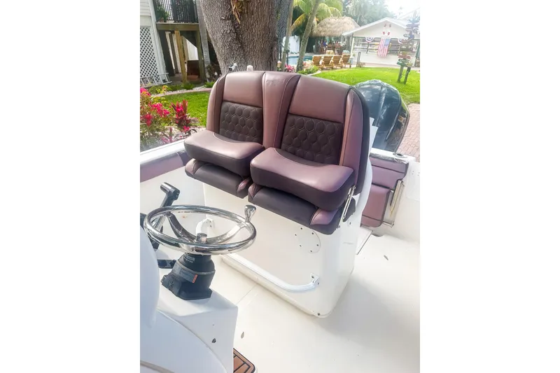 Slide: The Image of 2017 Tidewater 230 CC Adventure boat interior with dual cushioned seats and steering wheel. - 11