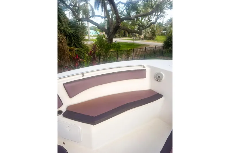 Slide: The Image of 2017 Tidewater 230 CC Adventure boat interior with cushioned seating and scenic background. - 14