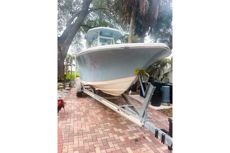Slide: The Image of 2017 Tidewater 230 CC Adventure boat on trailer, parked on brick driveway. - 2