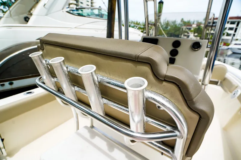 Slide: The Image of 2022 Key West 219 FS boat seat with rod holders in a marina setting. - 12