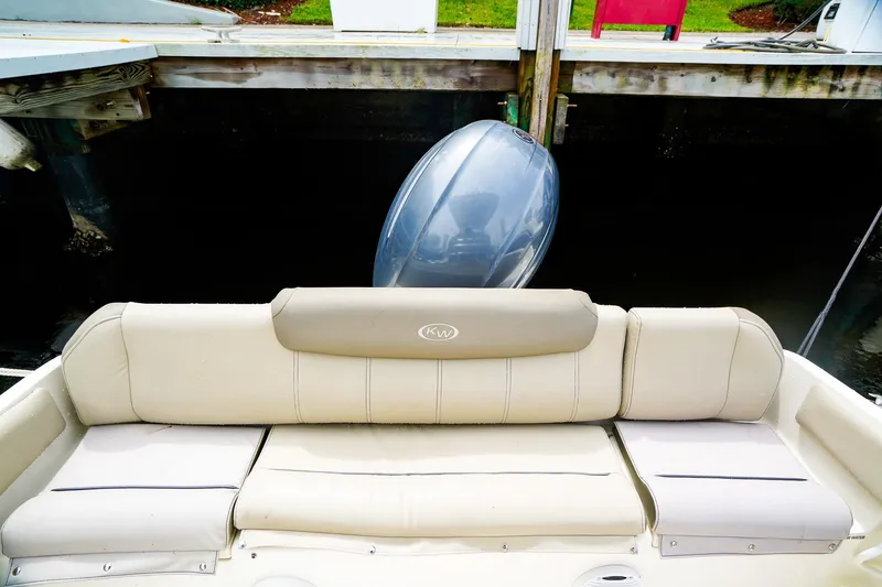 Slide: The Image of 2022 Key West 219 FS boat with beige seating and outboard motor at dock. - 6