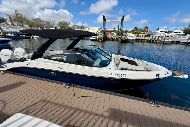 Slide: The Image of 2025 Sea Ray SLX 280 Outboard boat docked at marina under blue sky. - 12