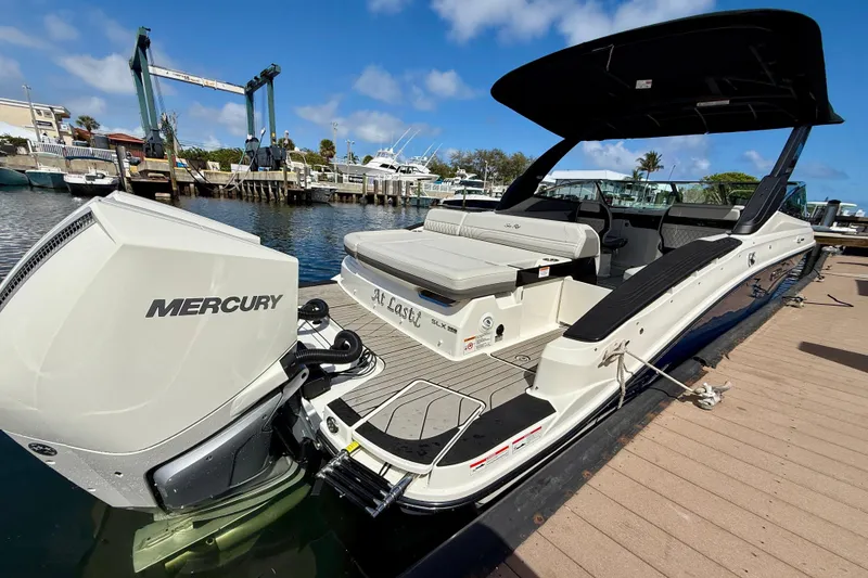Slide: The Image of 2025 Sea Ray SLX 280 Outboard boat docked, featuring a Mercury engine. - 17