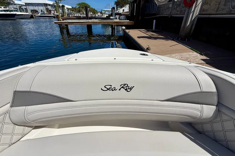 Slide: The Image of 2025 Sea Ray SLX 280 Outboard boat interior with logo, docked by the water. - 28