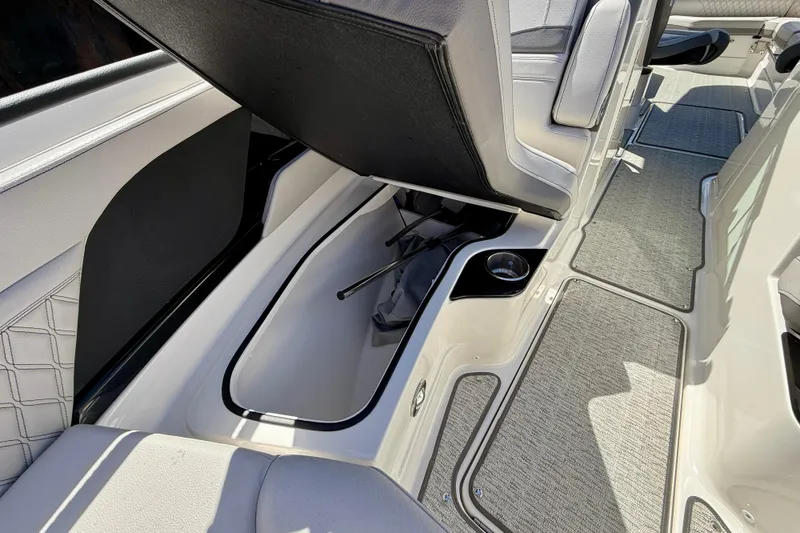 Slide: The Image of 2025 Sea Ray SLX 280 Outboard boat interior storage compartment with open seat and cup holder. - 31