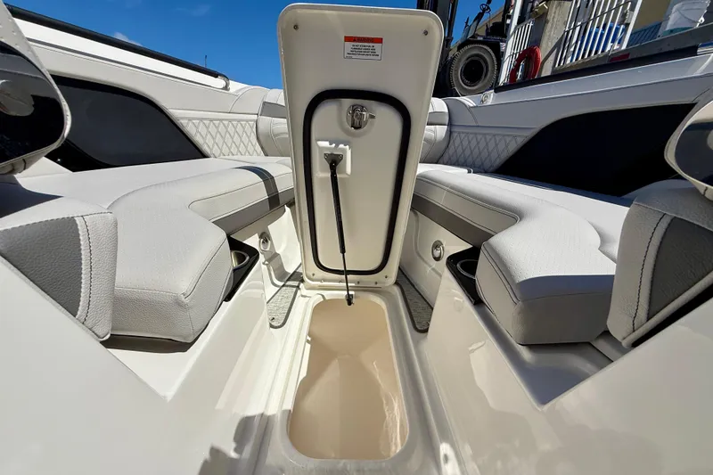 Slide: The Image of 2025 Sea Ray SLX 280 Outboard interior with open storage compartment and luxurious seating. - 32