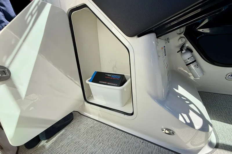 Slide: The Image of 2025 Sea Ray SLX 280 Outboard storage compartment with fire extinguisher and battery box. - 40