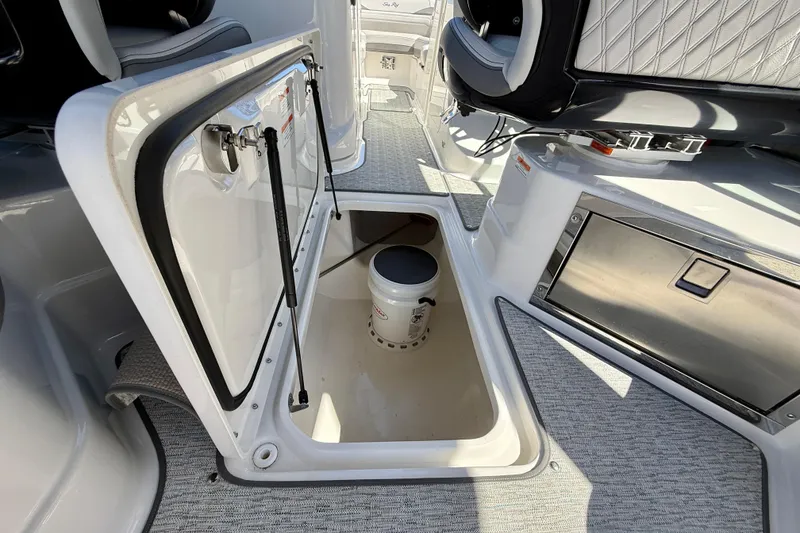 Slide: The Image of 2025 Sea Ray SLX 280 Outboard interior storage compartment with bucket and seating. - 41