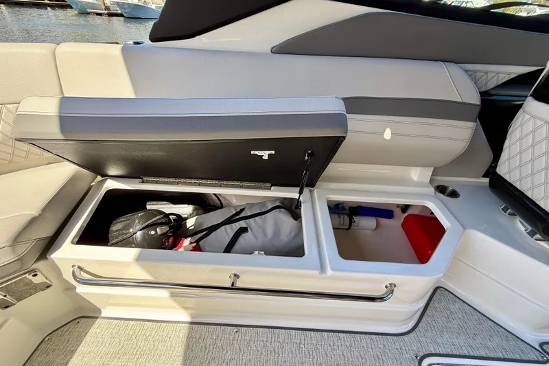 Slide: The Image of 2025 Sea Ray SLX 280 Outboard boat storage compartments with open seat lid. - 44