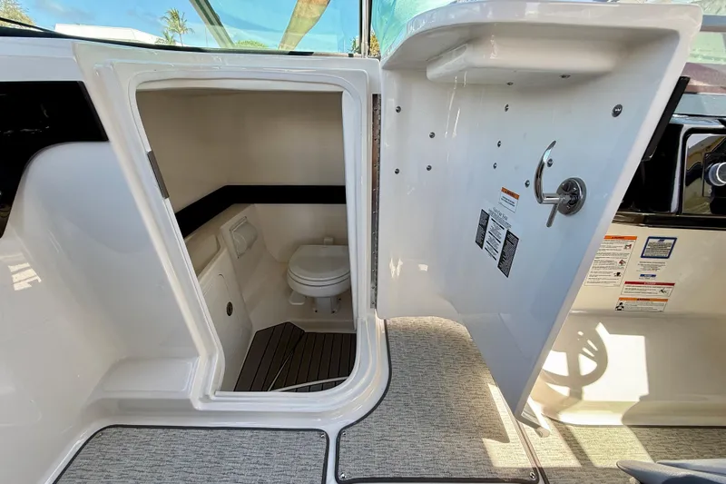 Slide: The Image of 2025 Sea Ray SLX 280 Outboard boat interior with open bathroom door. - 53