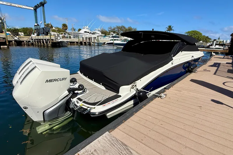 Slide: The Image of 2025 Sea Ray SLX 280 Outboard boat docked with Mercury engine, covered in black. - 58