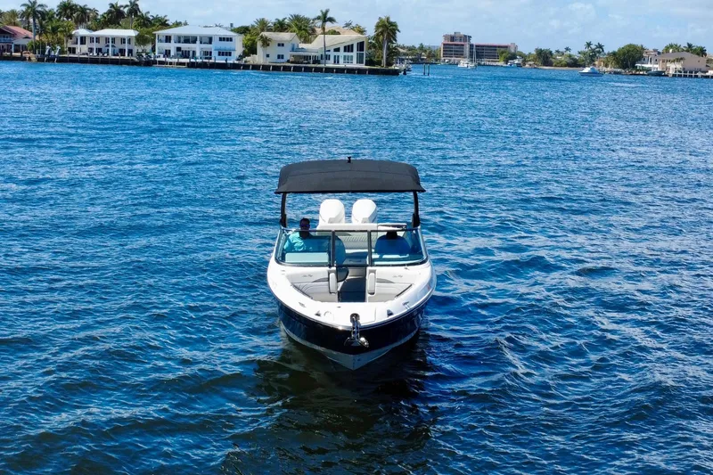 Slide: The Image of 2025 Sea Ray SLX 280 Outboard boat on blue water near waterfront homes. - 8