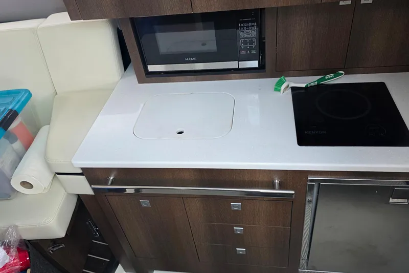 Slide: The Image of Compact kitchen area in a 2017 Monterey 360 Sport Coupe with modern appliances. - 20