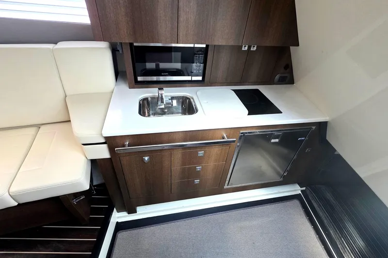 Slide: The Image of Compact kitchen in 2017 Monterey 360 Sport Coupe with sink, stove, and seating. - 24